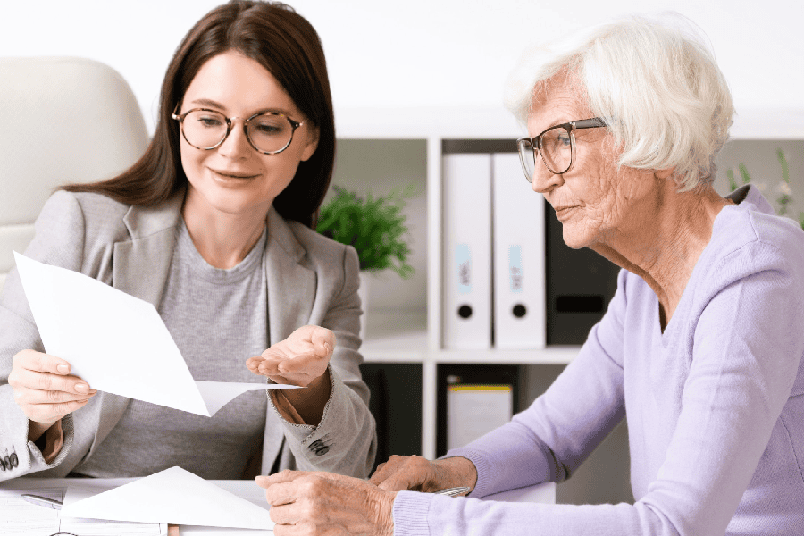 unicorn real estate team member speaking with an elderly woman in an office